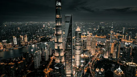Vista aérea del horizonte iluminado de Shanghái de noche junto al río Huangpu
